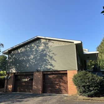 Modern home exterior featuring Variform siding and dual garage doors, set in a residential area, showcasing recent renovations by E-Stern Construction.